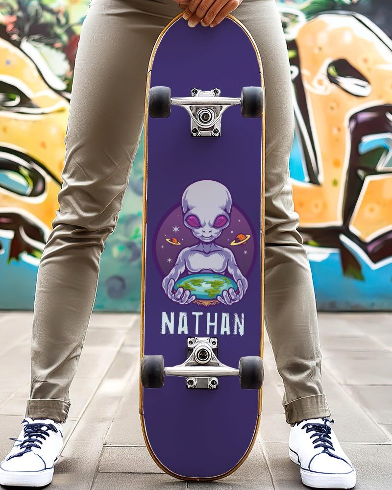 Person holding a purple skateboard with an alien graphic holding Earth and the name Nathan.