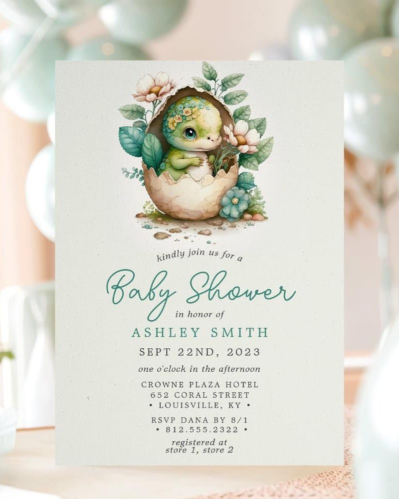 Baby shower invitation featuring a cute dinosaur hatching from an egg surrounded by flowers.