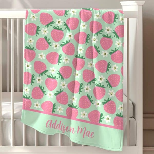 Mint Green Baby Blanket With A Pink Strawberry And Flower Pattern And Personalized Name.