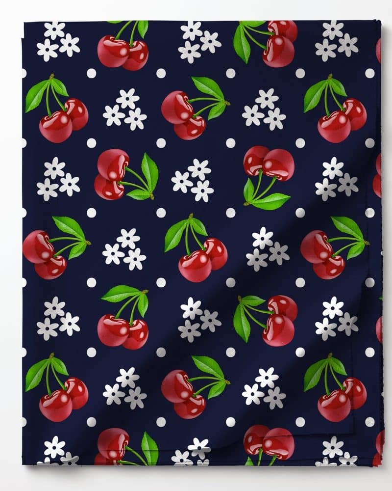 Dark blue fabric with a repeating pattern of red cherries and white flowers.