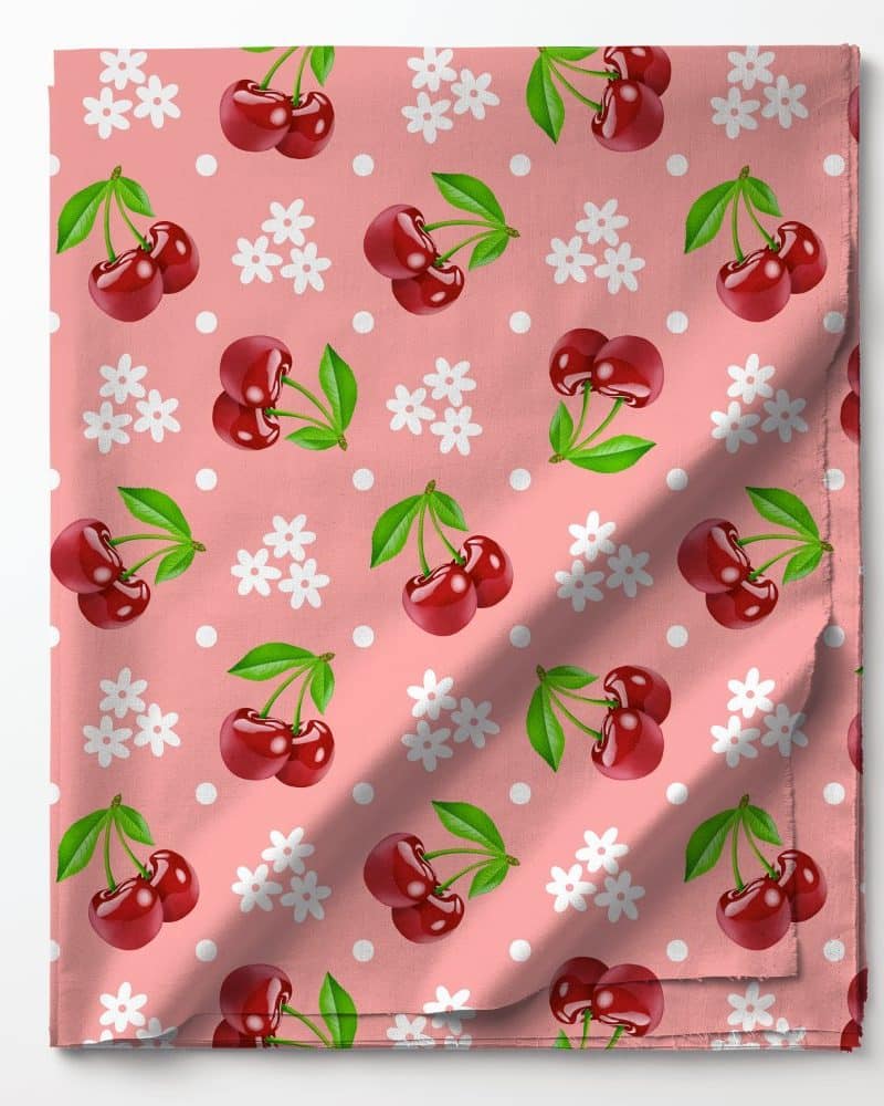 Pink fabric with a repeating pattern of cherries and small white flowers.