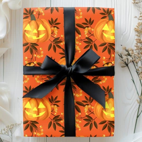 Halloween Gift Wrapped In Orange Paper With Jack-O'-Lantern And Berry Pattern, Tied With A Black Ribbon.