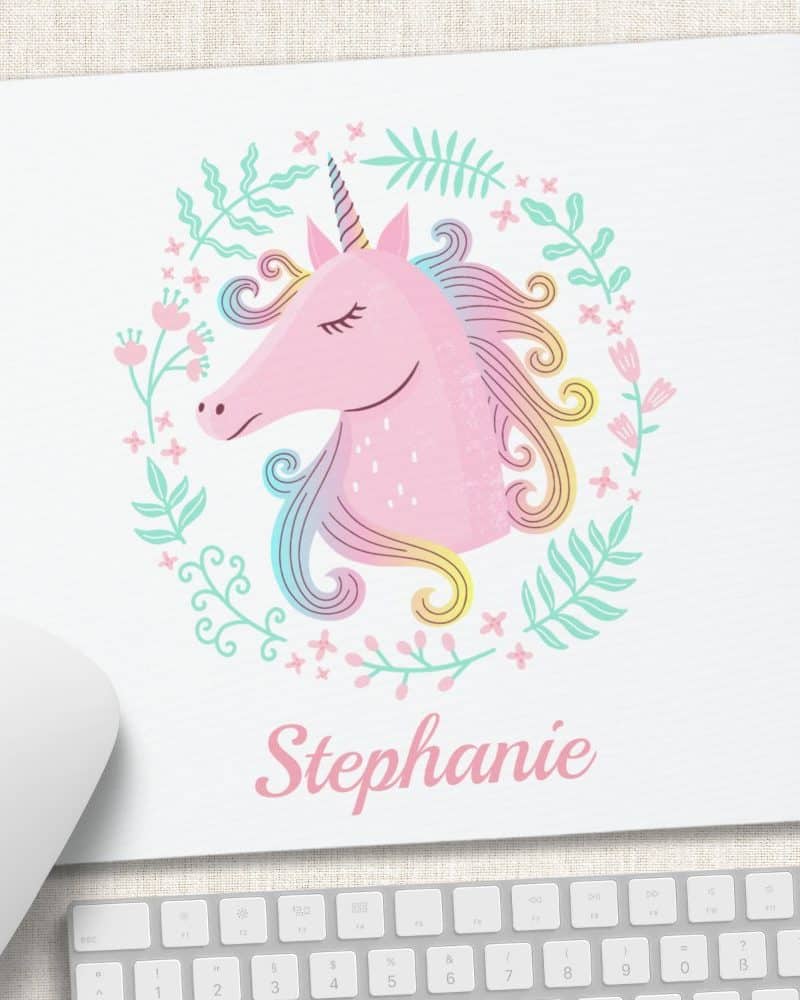 Pink unicorn head with rainbow mane, surrounded by flowers, on a mousepad personalized with the name Stephanie.
