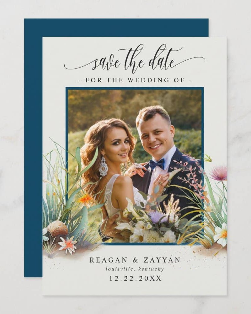 Save the date card featuring a photo of a bride and groom, surrounded by watercolor floral details.