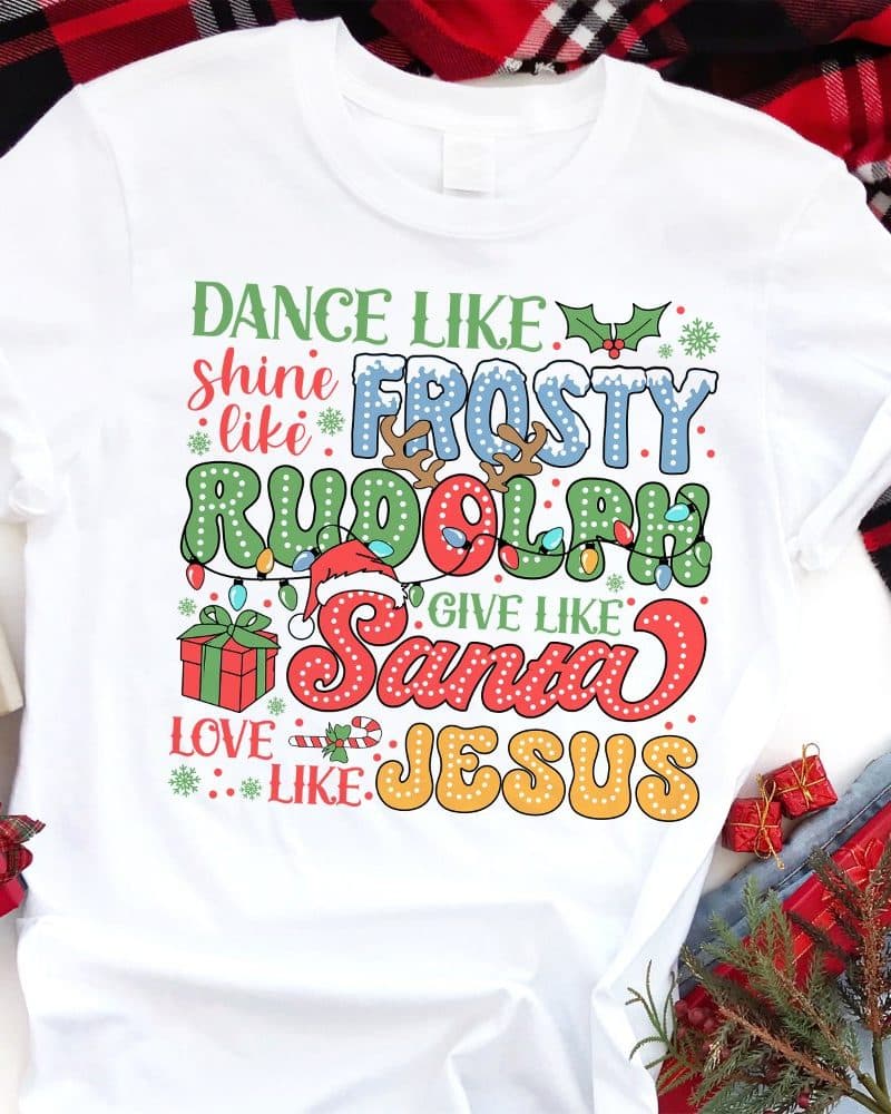 White t-shirt with a Christmas design featuring text that says Dance Like Frosty, Shine Like Rudolph, Give Like Santa, and Love Like Jesus.