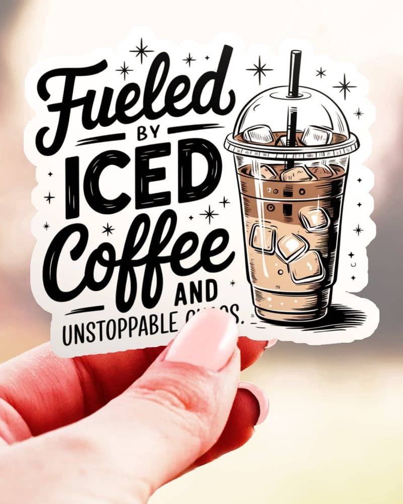 Hand holding a sticker featuring a drawing of an iced coffee cup and the text Fueled by Iced Coffee.