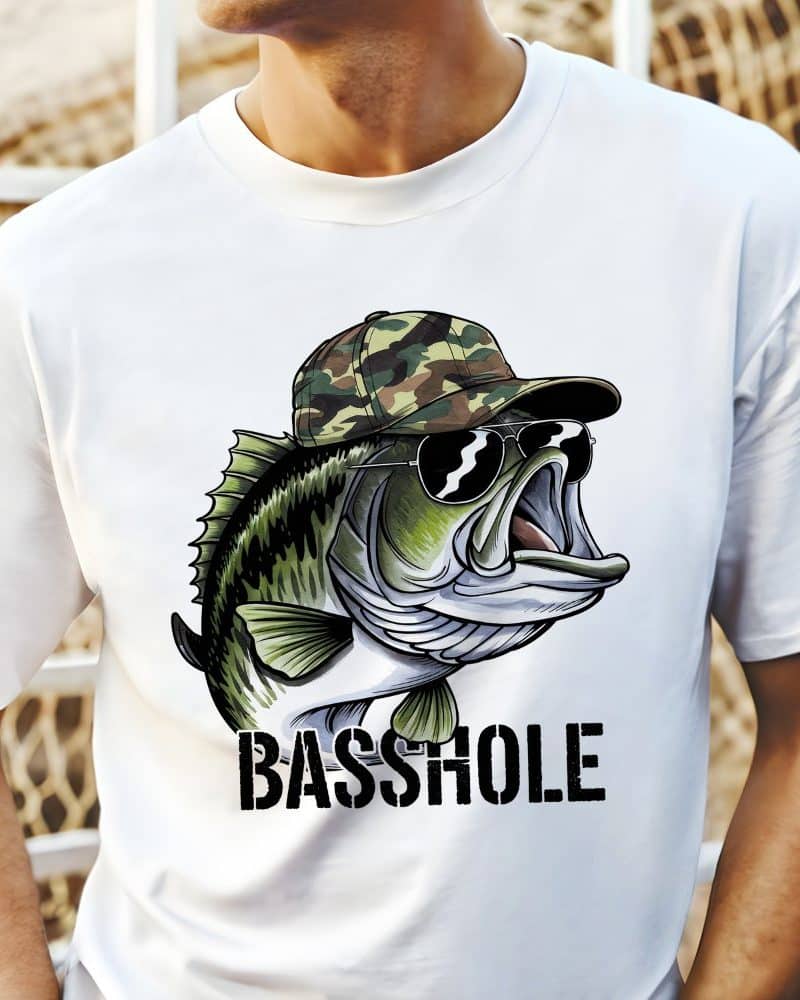 White t-shirt featuring a cartoon bass wearing sunglasses and a camouflage hat; the word BASSHOLE is printed below the fish.