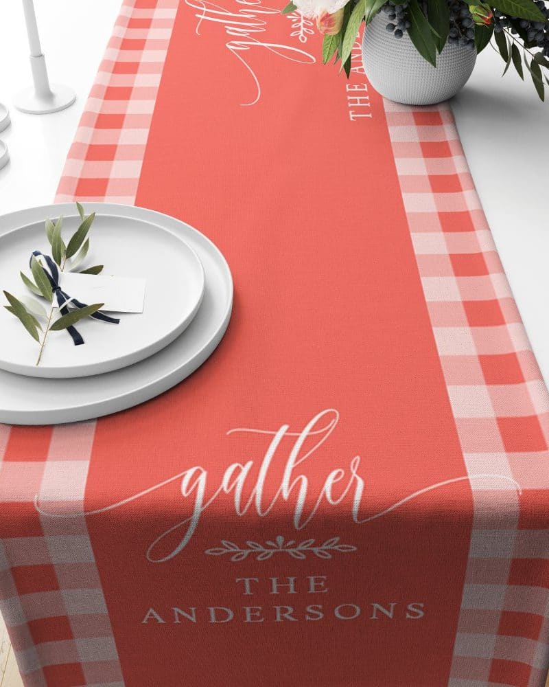 Coral and white gingham table runner with the word gather and the family name Andersons.