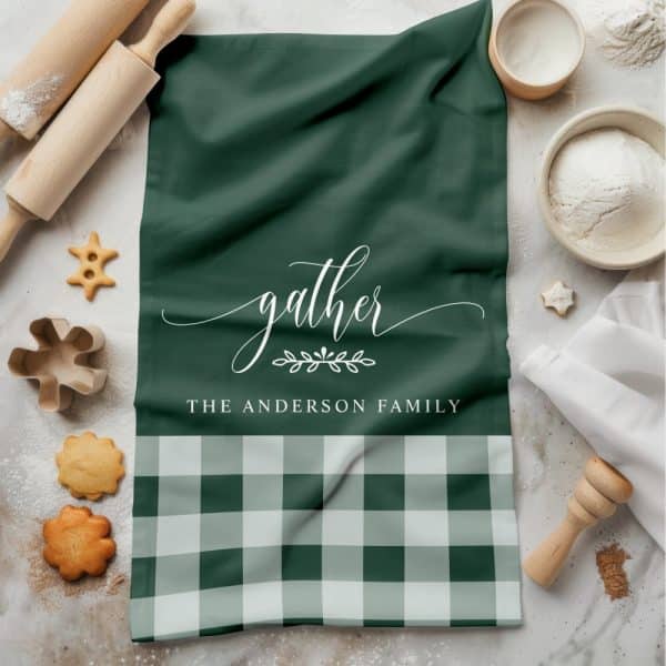 Green Tea Towel With The Word Gather And The Anderson Family In White Lettering. The Bottom Features A Green And White Gingham Pattern.