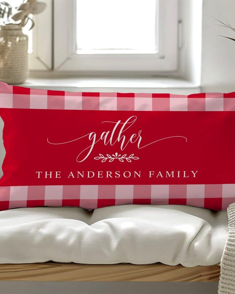 Red and white gingham rectangular pillow with the word gather and The Anderson Family in white script.