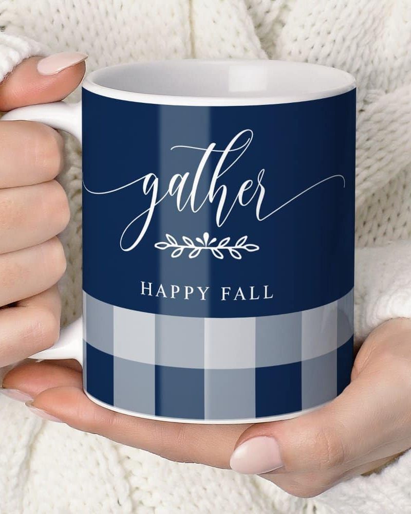 Hands holding a navy blue and gray gingham mug that says Gather and Happy Fall.
