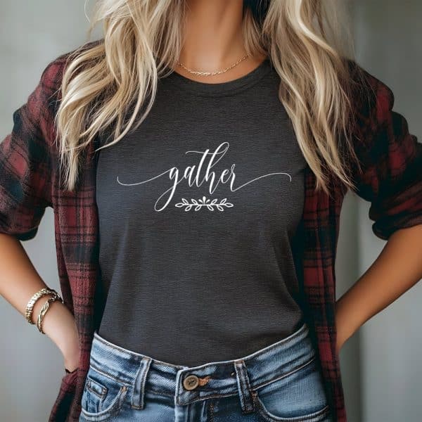 Woman Wearing A Dark Gray T-Shirt With The Word Gather In White Script.