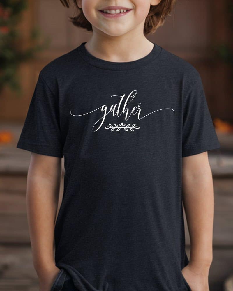 Child wearing a dark gray t-shirt with the word gather in white script lettering and a small leaf design underneath.