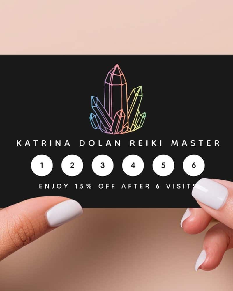 Black loyalty card featuring a rainbow crystal graphic and Katrina Dolan Reiki Master text; six circles for tracking visits, with a 15% discount after six visits.