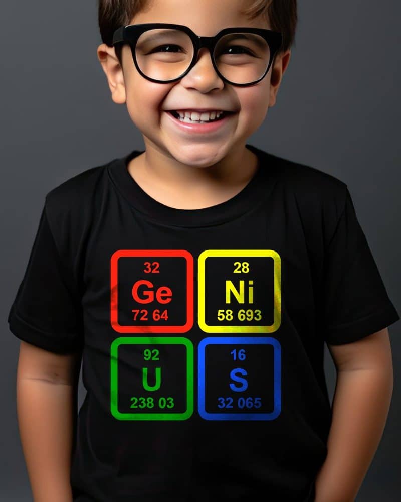 Smiling boy wearing a black t-shirt with periodic table elements spelling out GENIUS.