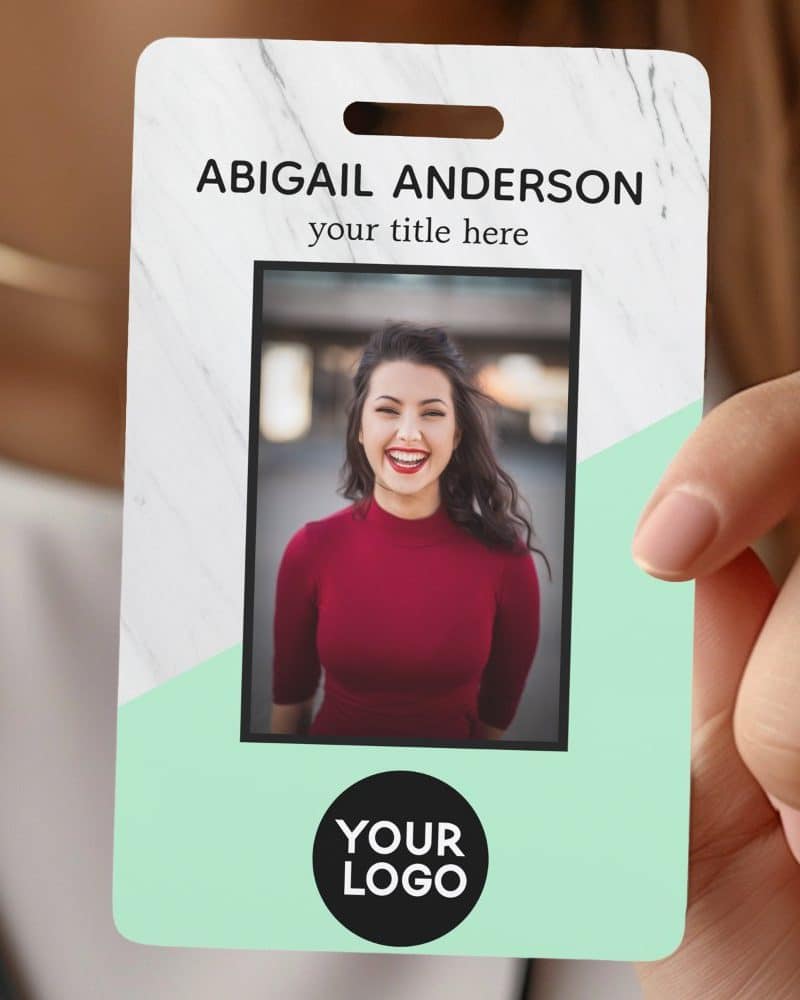 A hand holds a mint and marble patterned ID badge featuring a smiling woman's photo, her name, title placeholder, and a logo placeholder.