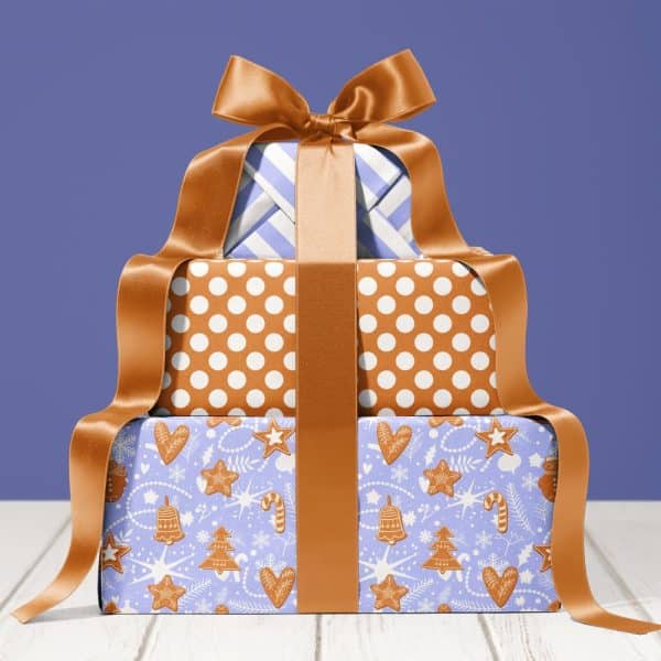 Stack Of Three Festively Wrapped Presents With A Large Brown Ribbon.