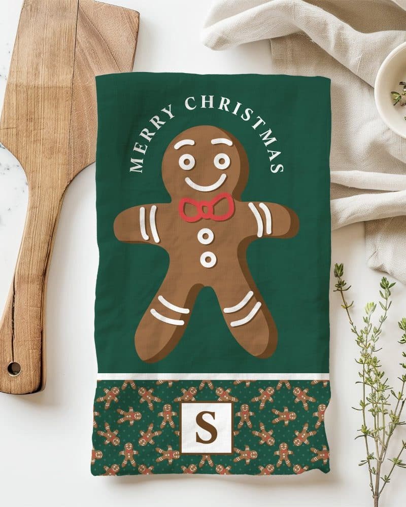 Green Christmas tea towel with a large gingerbread man illustration and Merry Christmas text.