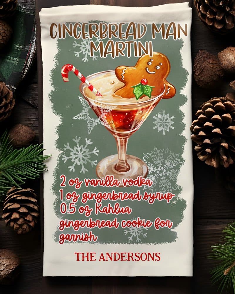 A kitchen tea towel with a recipe for a gingerbread man martini, illustrated with a martini glass garnished with a gingerbread man.
