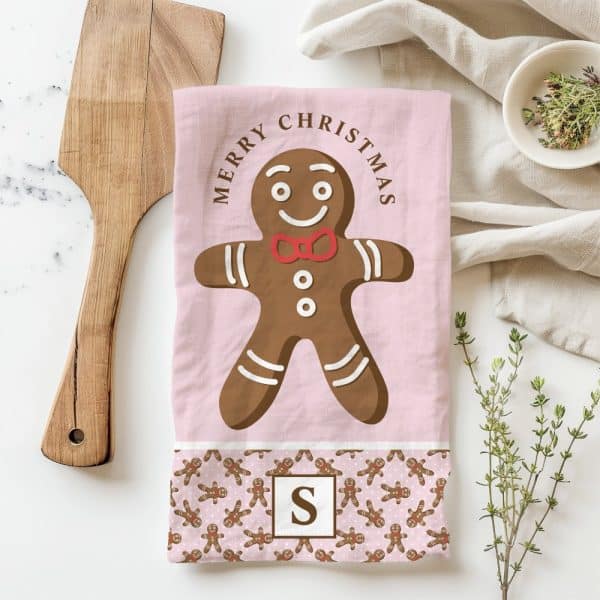Pink Christmas Tea Towel With A Large Gingerbread Man And Merry Christmas Text.