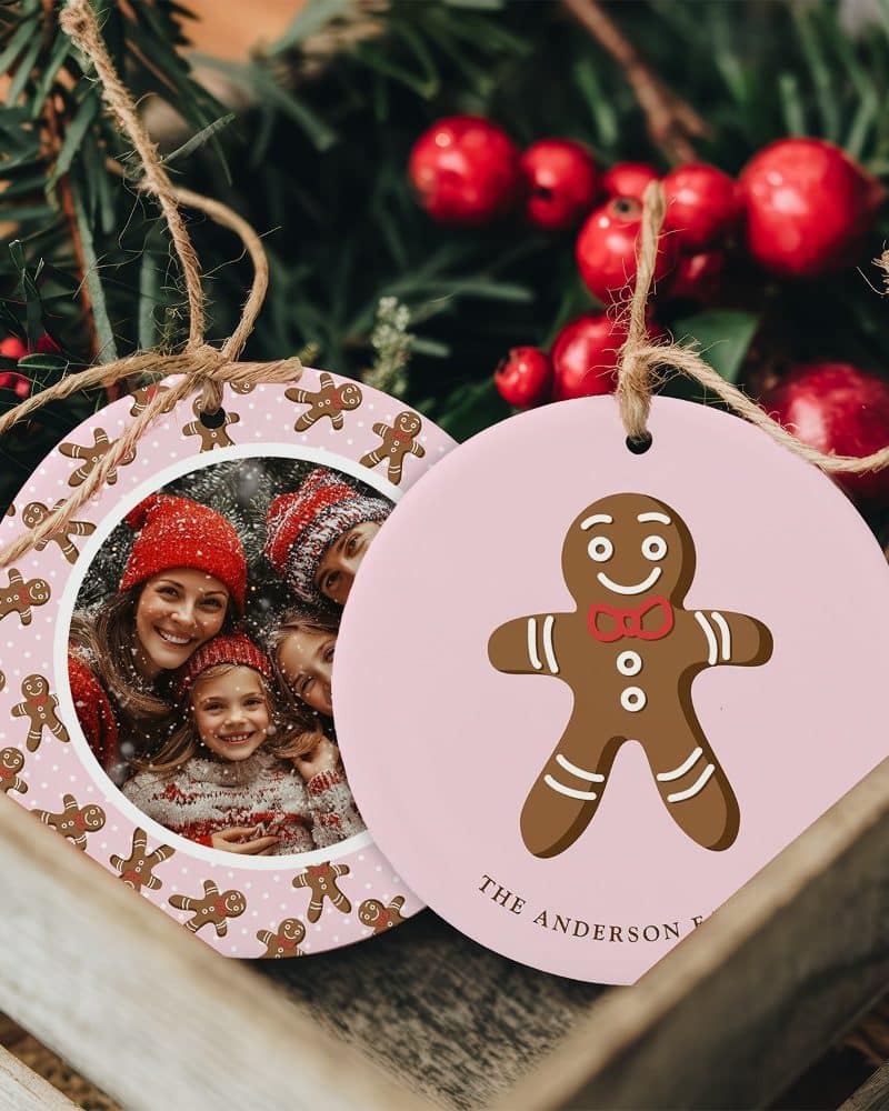 Two pink Christmas ornaments. One features a family photo surrounded by gingerbread men. The other shows a single gingerbread man.