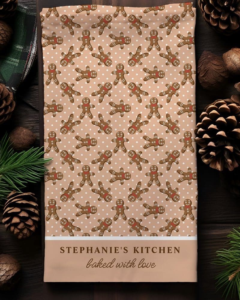 Kitchen towel with a pattern of gingerbread men and the text Stephanie's Kitchen baked with love.