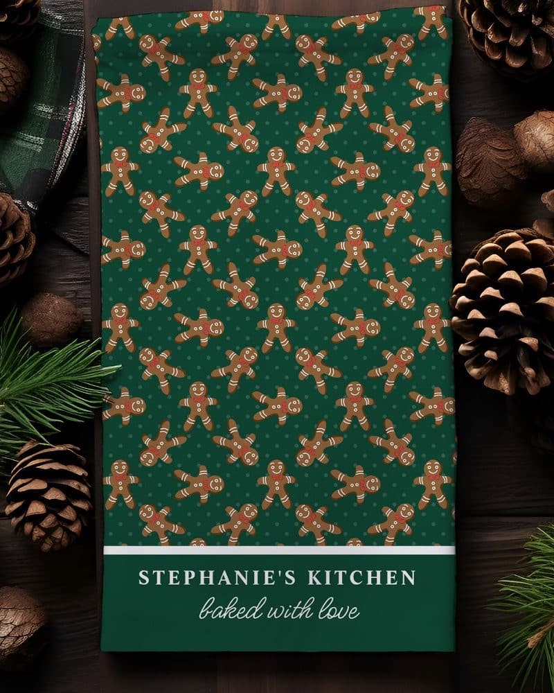 Green tea towel with a repeating pattern of gingerbread men, personalized with Stephanie's Kitchen baked with love.