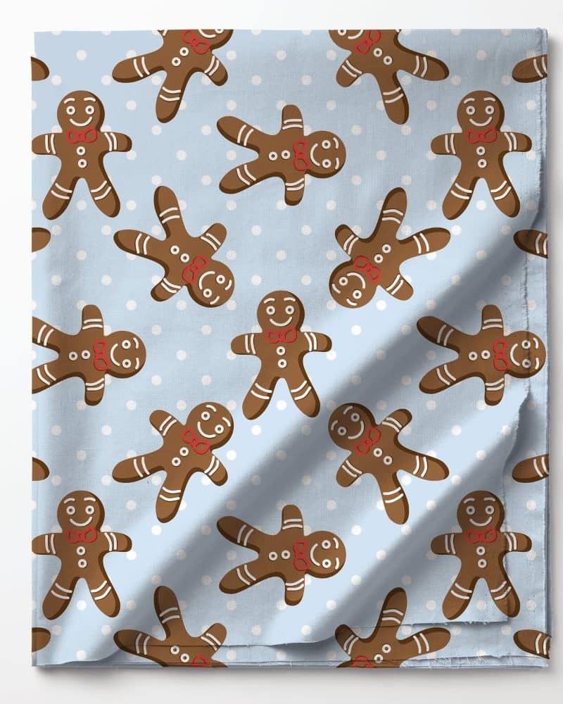 Light blue fabric with a repeating pattern of gingerbread men and white dots.