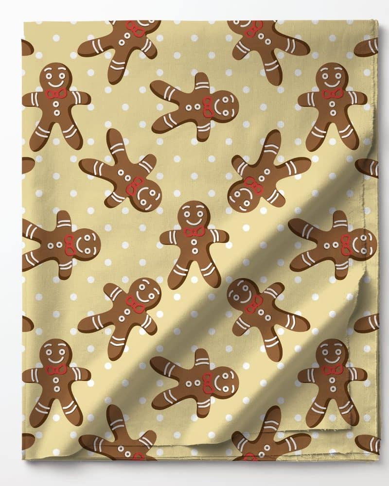 Beige fabric with a repeating pattern of brown gingerbread men wearing red bow ties on a white polka dot background.