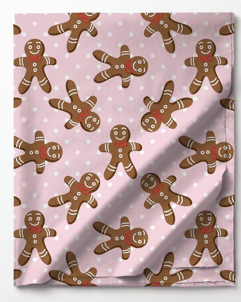 Pink fabric with a repeating pattern of gingerbread men wearing red bow ties.
