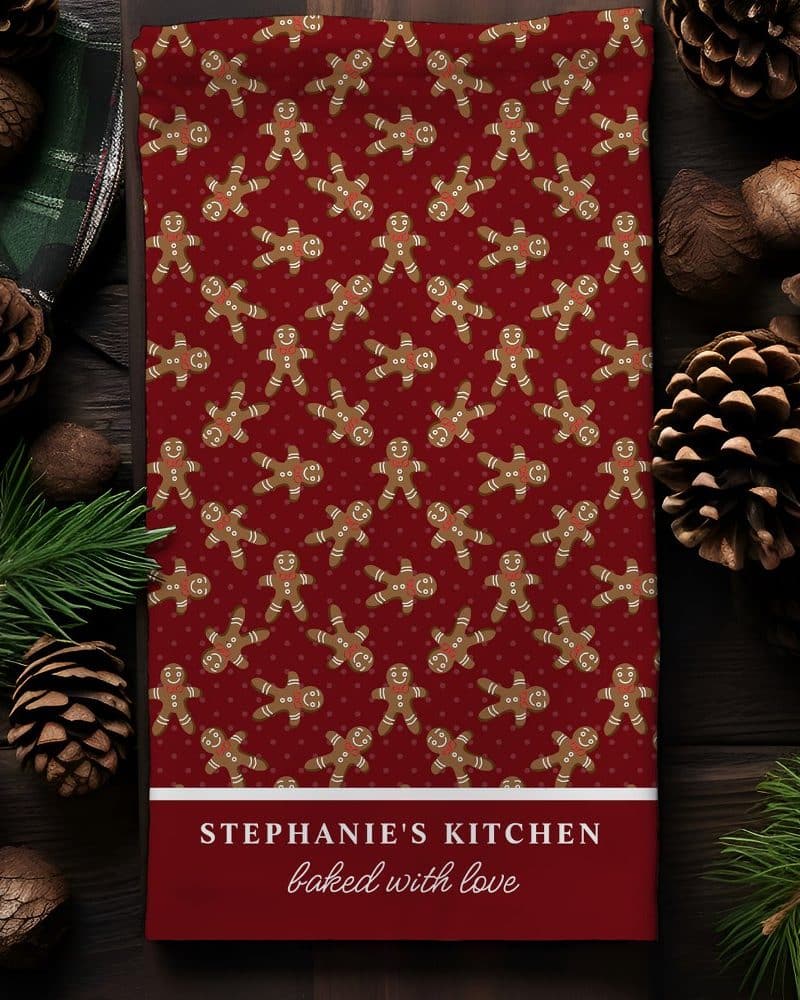Red kitchen towel with a repeating pattern of gingerbread men, personalized with Stephanie's Kitchen baked with love.