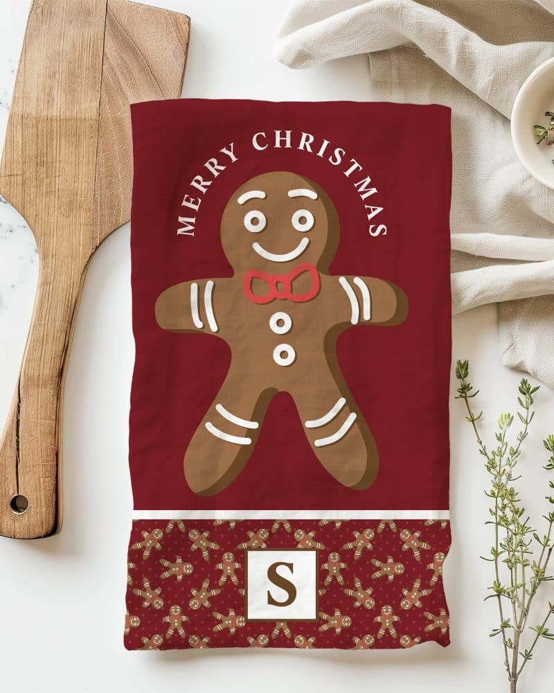Red Christmas tea towel featuring a large gingerbread man and the text Merry Christmas.