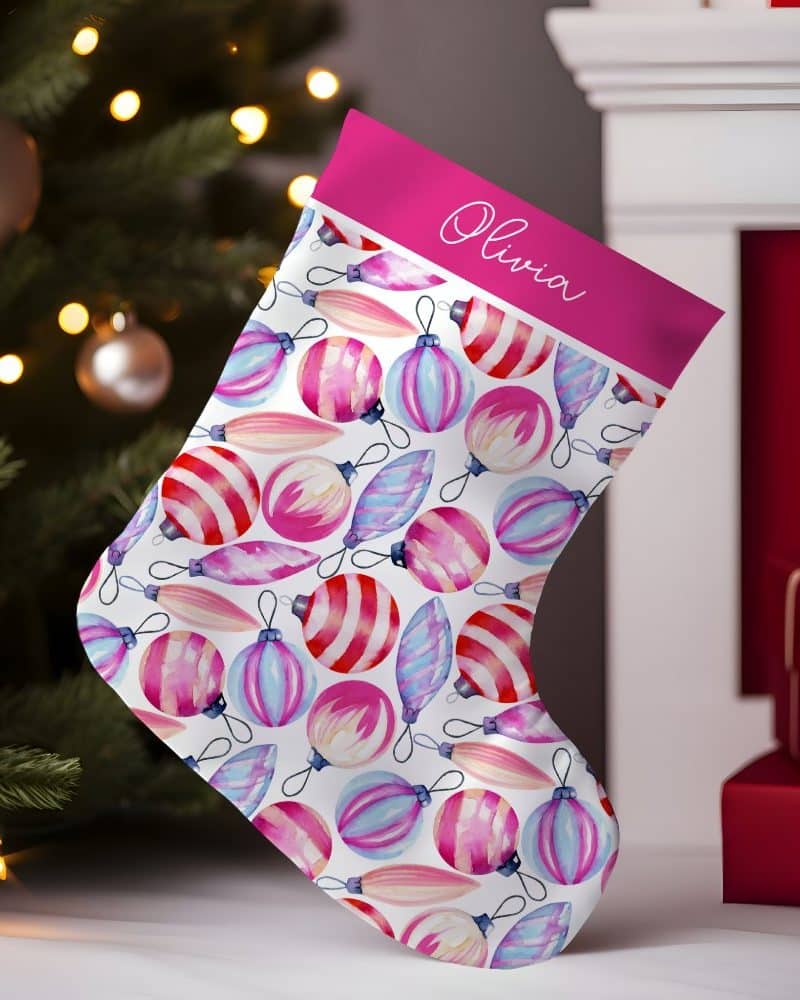 Personalized Christmas stocking with a pink cuff and a watercolor ornament pattern.