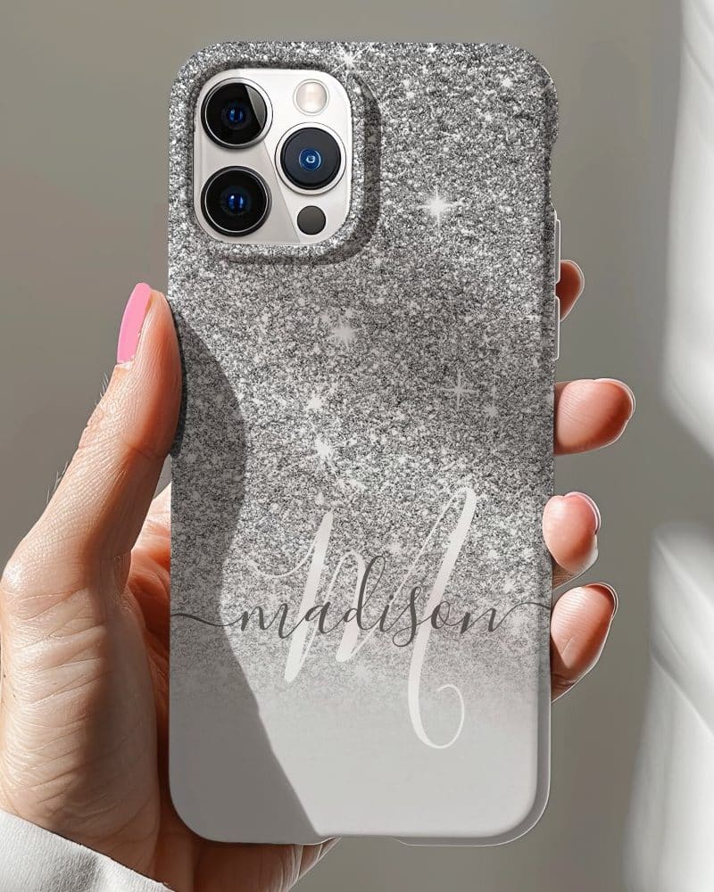 Hand holding a silver glitter iPhone case with the name Madison in script.