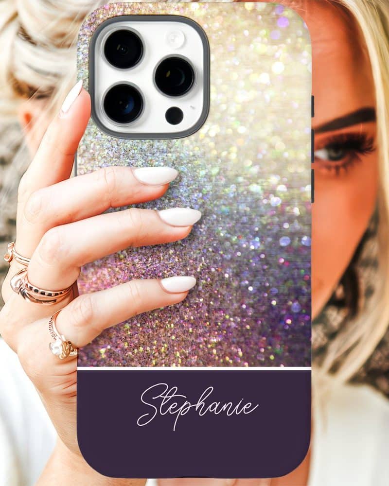 A woman's hand holding up a sparkly iridescent phone case with the name Stephanie on it.