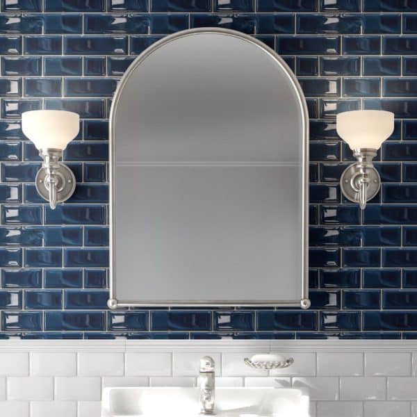 Arch-Shaped Mirror Flanked By Wall-Mounted Lights Above A Bathroom Sink.