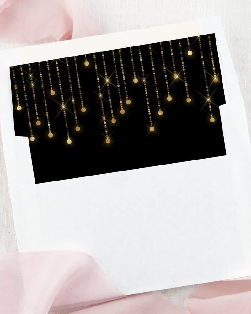 White envelope liner with a black insert featuring gold hanging lights.