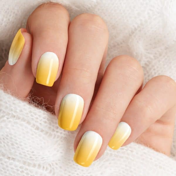 Close-Up Of A Hand With Yellow Ombre Nail Polish.