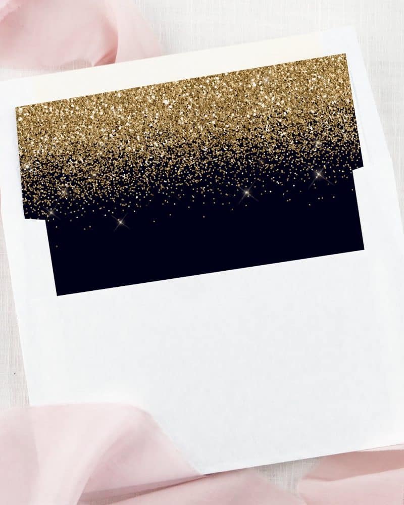 White envelope liner with a gold glitter ombre design over a dark navy blue background.