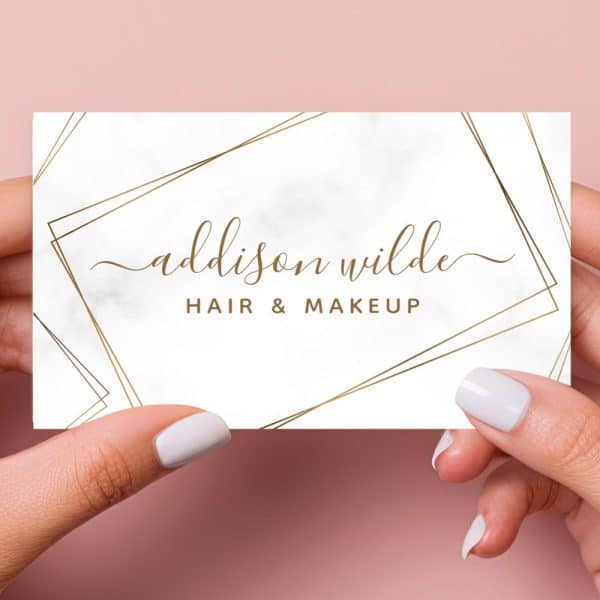 A White Business Card With Gold Geometric Lines And Marble Texture. The Name Addison Wilde Hair &Amp; Makeup Is Written In Elegant Script.