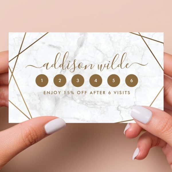 A Marble-Textured Loyalty Card Featuring Gold Geometric Lines, The Name Addison Wilde, And Six Circles For Punch-Hole Tracking; 15% Off After Six Visits.