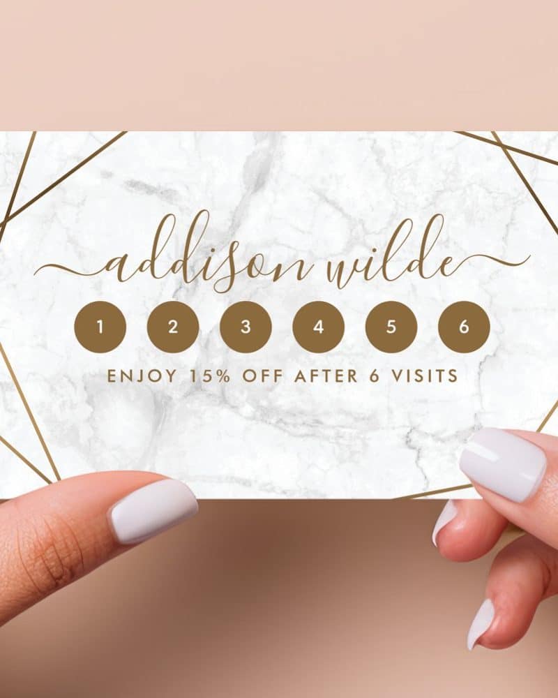 A marble-textured loyalty card featuring gold geometric lines, the name Addison Wilde, and six circles for punch-hole tracking; 15% off after six visits.
