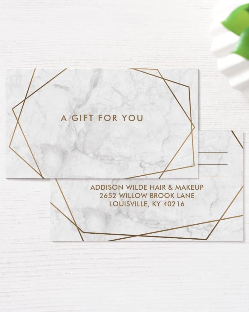 Gift certificate with marble background and gold geometric lines; business information included.