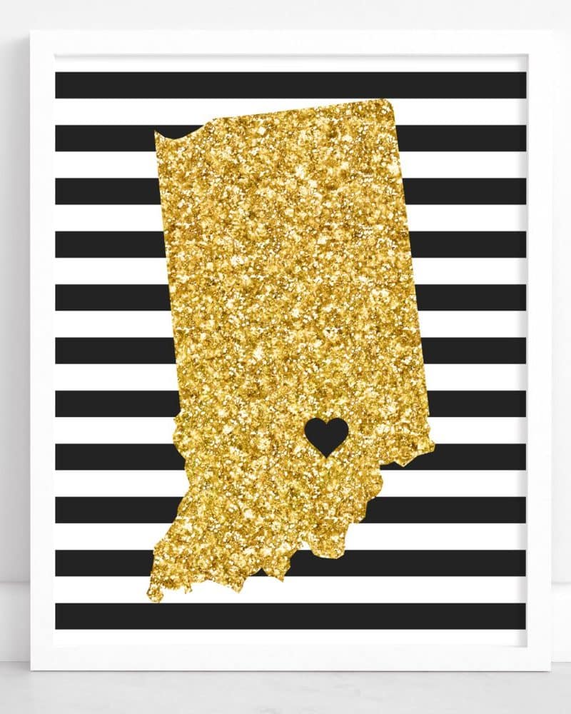 Gold glitter outline of Indiana with a small black heart in the center, on black and white striped background.