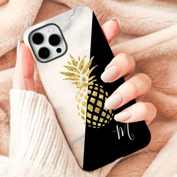 A Hand Holding A Phone Case Featuring A Gold Glitter Pineapple Design On A Marble And Black Background.