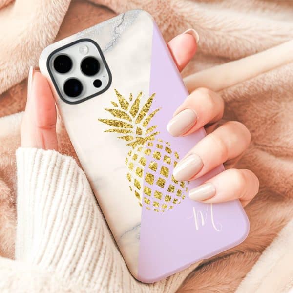 A Hand Holding A Phone Case Featuring A Gold Glitter Pineapple Design On A Marble And Lavender Background.