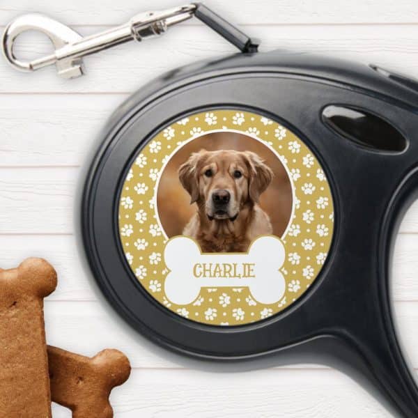 Retractable Dog Leash With A Personalized Circular Design Featuring A Golden Retriever Photo, Paw Prints, A Bone-Shaped Name Tag Reading Charlie, And A Mustard Yellow Background.