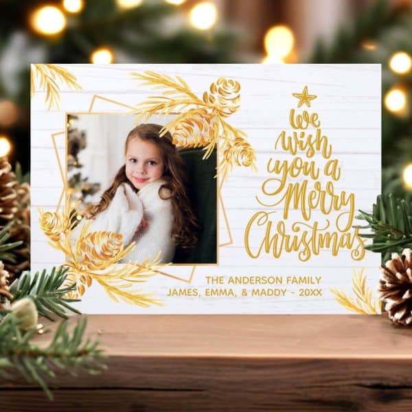 Christmas Card Featuring A Photo Of A Young Girl, Gold Pine Cone Accents, And The Message We Wish You A Merry Christmas.