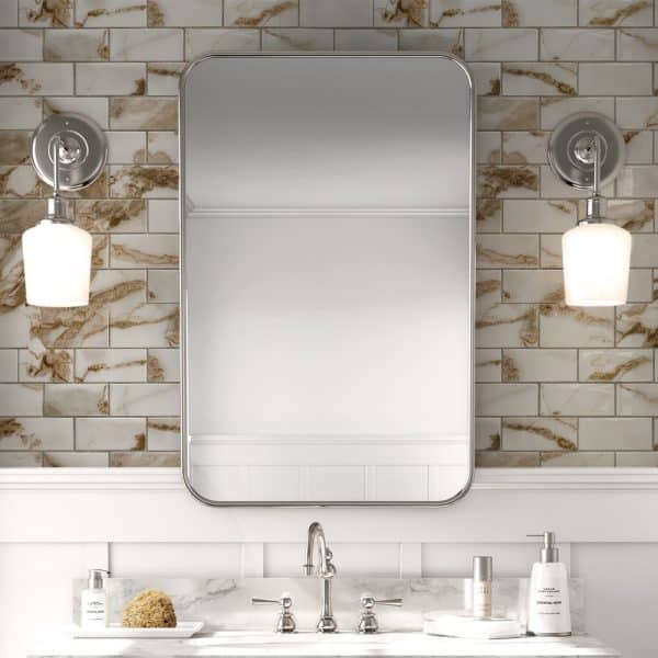 Bathroom Vanity With A Rectangular Mirror Flanked By Wall-Mounted Lights And A Marble-Look Backsplash.