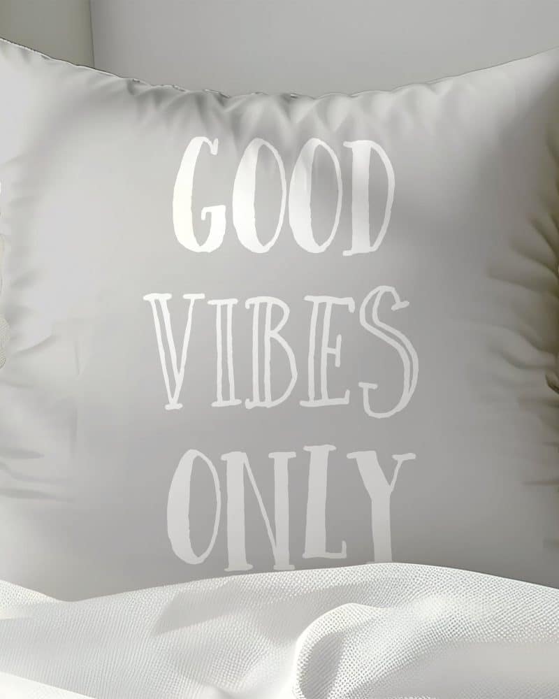 Light gray pillow with the words Good Vibes Only in white.